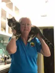 Cindy C, Co-Owner of Bauser's Pet Training, holding two cats